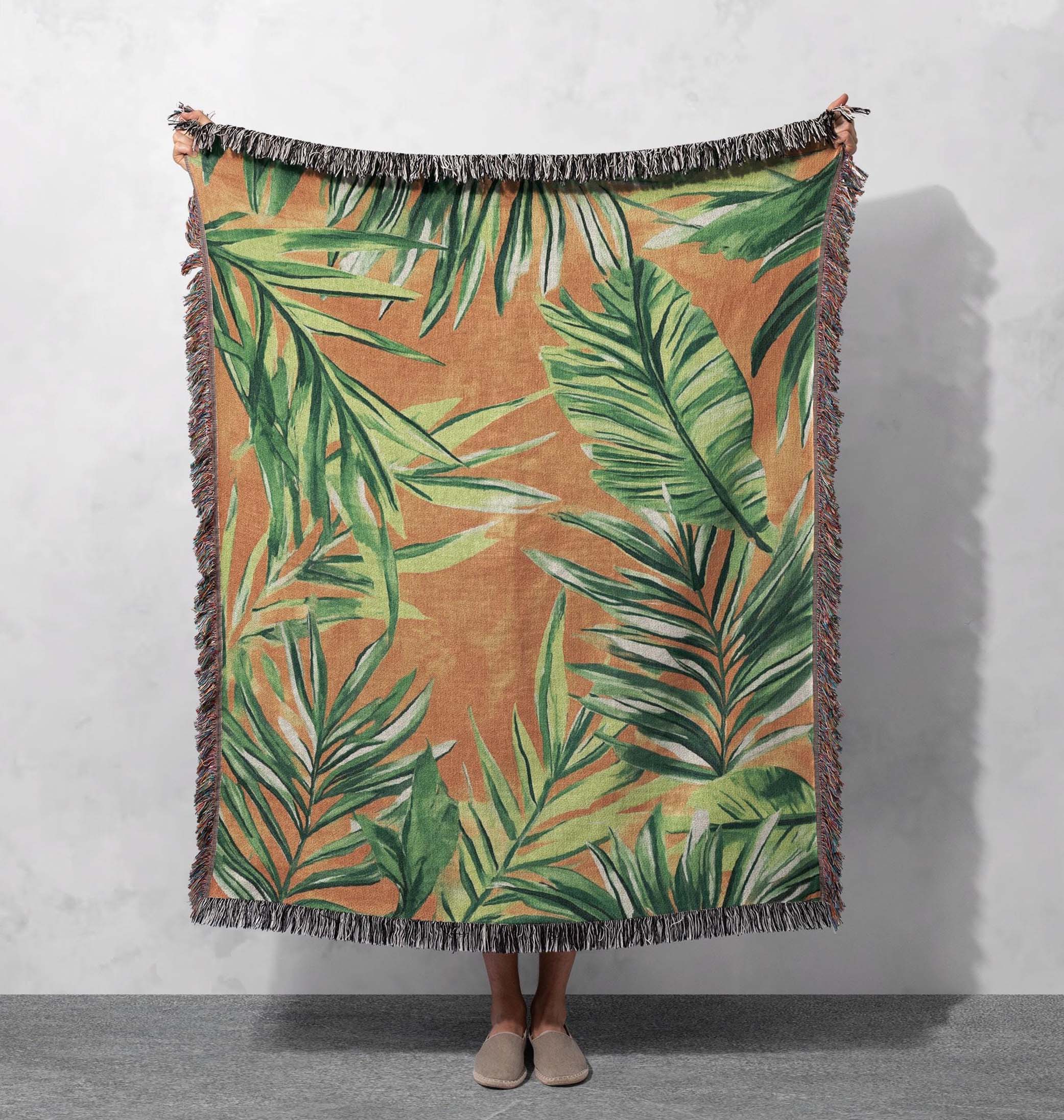 tropical palm leaf woven blanket green foliage on warm earthy background with fringed edges cottagecore tapestry