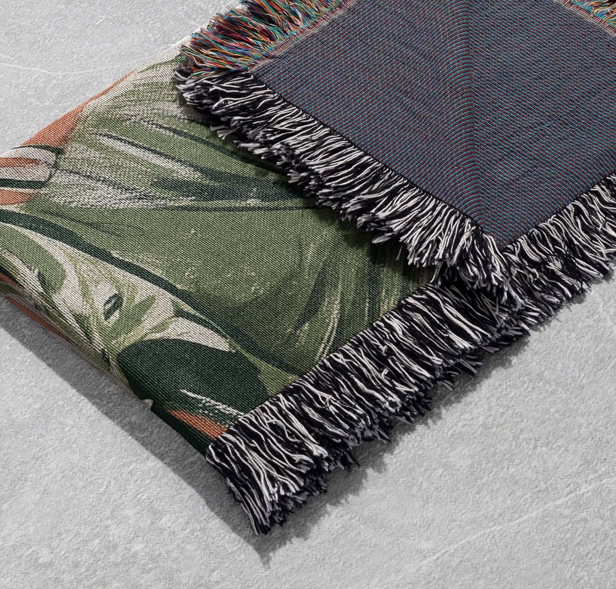 tropical leaf woven blanket bold green leaves on warm earthy background with fringed edges cottagecore tapestry